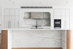 Modern white kitchen features sleek cabinets, marble backsplash, and stainless steel appliances in a minimalist design.