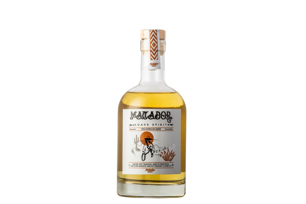 A glass bottle of Mazapan liqueur with a light amber colored liquid inside.