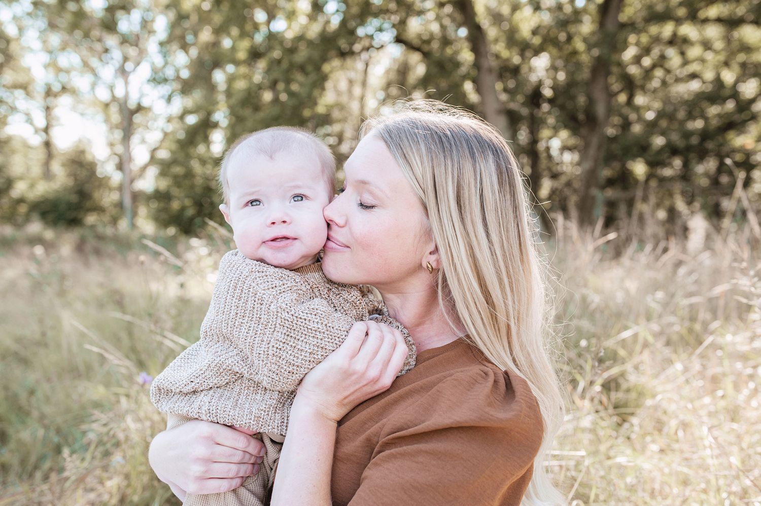 Familjefotografering en sensommardag. Sommaräng, högt gräs och jordiga toner. Mamma och son.
