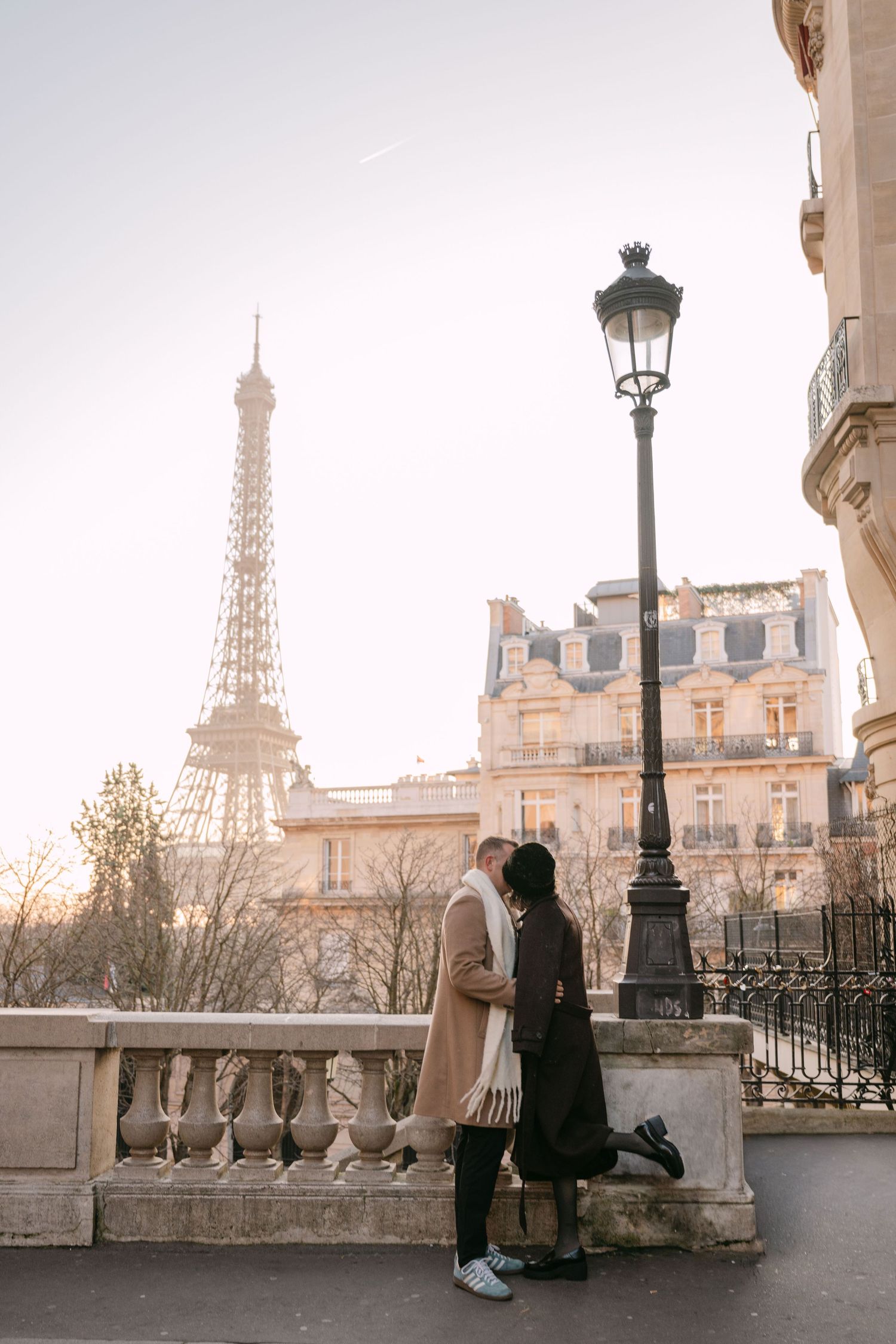 Newlyweds walking hand in hand on a street with the Eiffel Tower in Paris. Top locations for Paris photoshoot. Avenue des Camoens