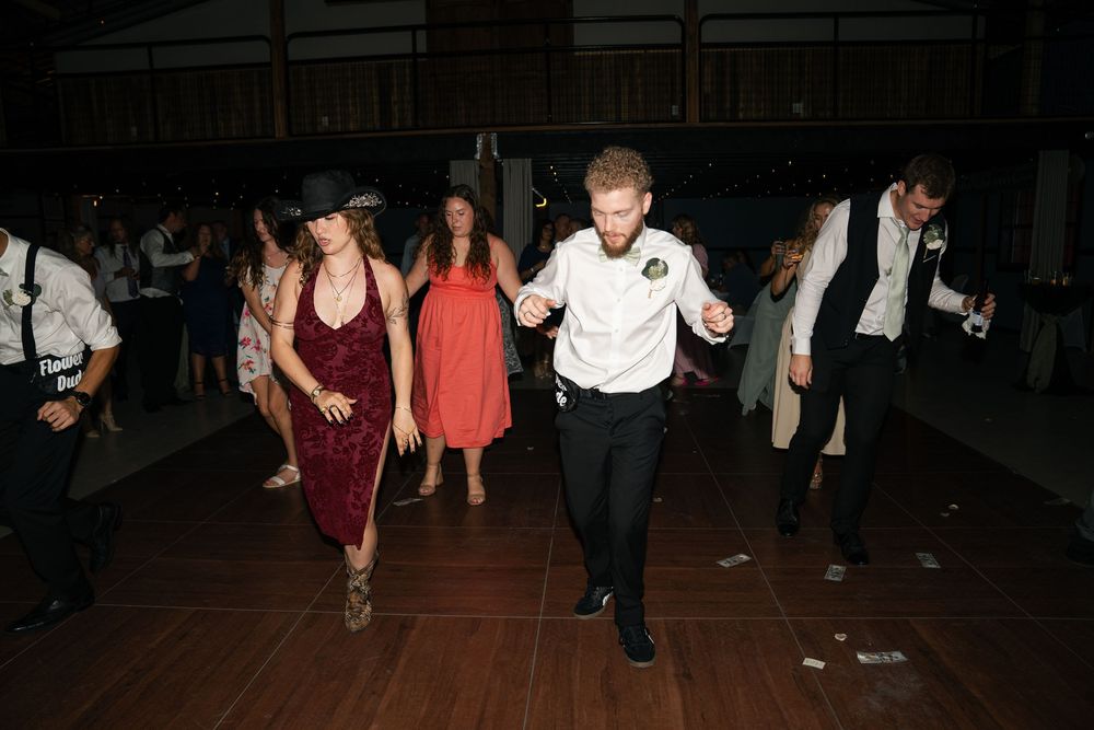 Guests dancing energetically on dance floor at lively wedding reception.