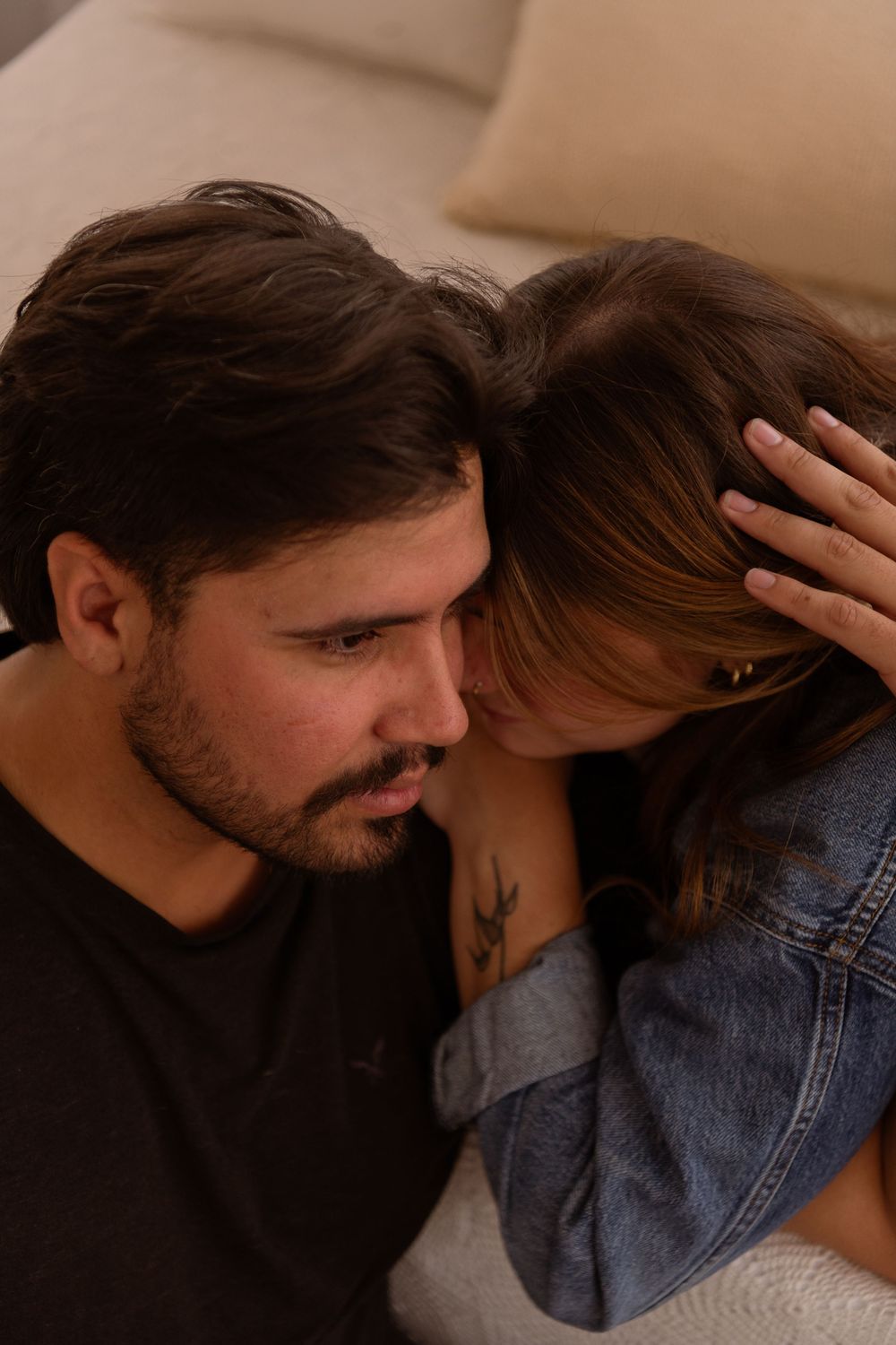 Couple sitting close together, woman resting head tenderly against mans forehead.