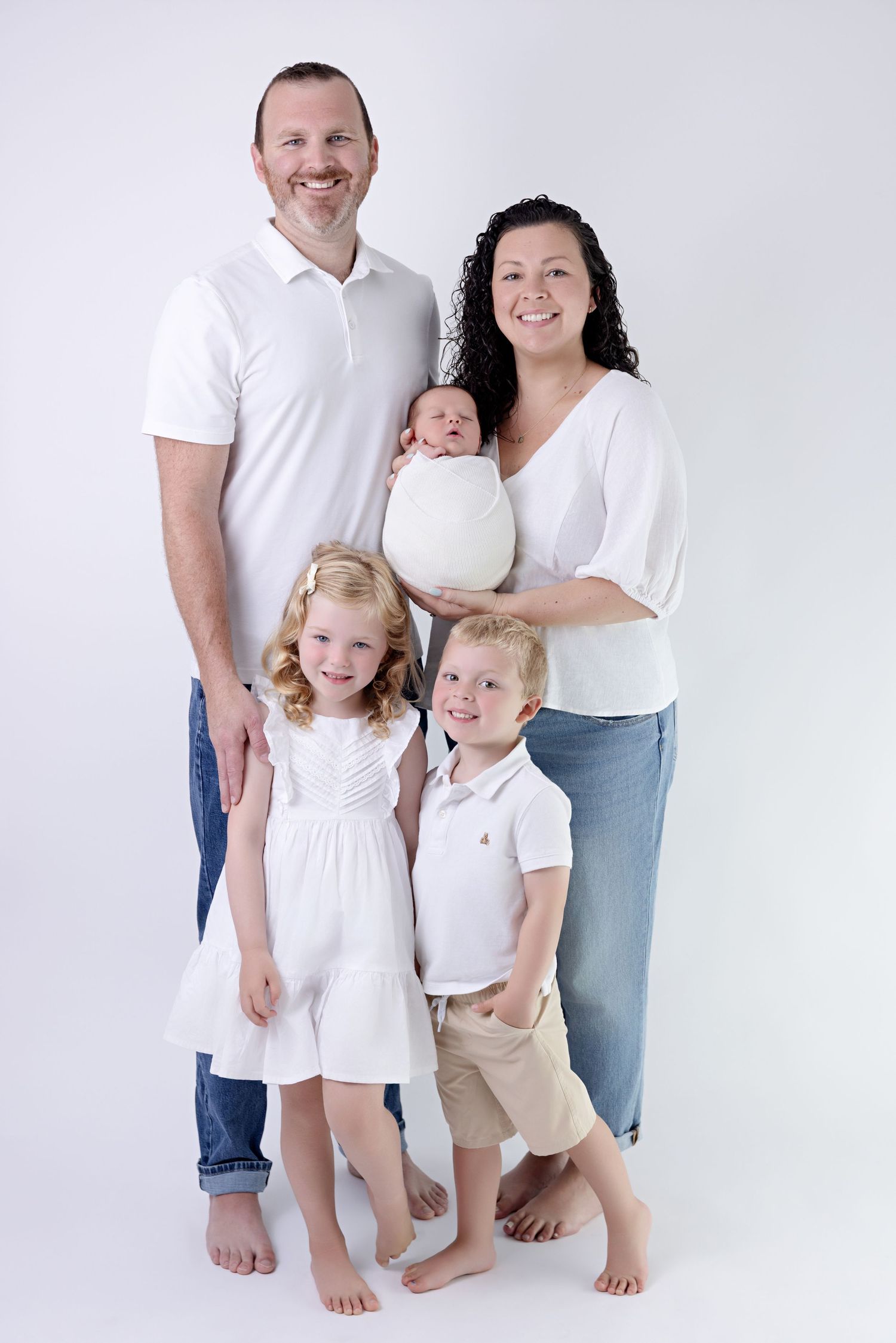 Family group seated together in front of decorative carved wall panel and woven basket wall decor.