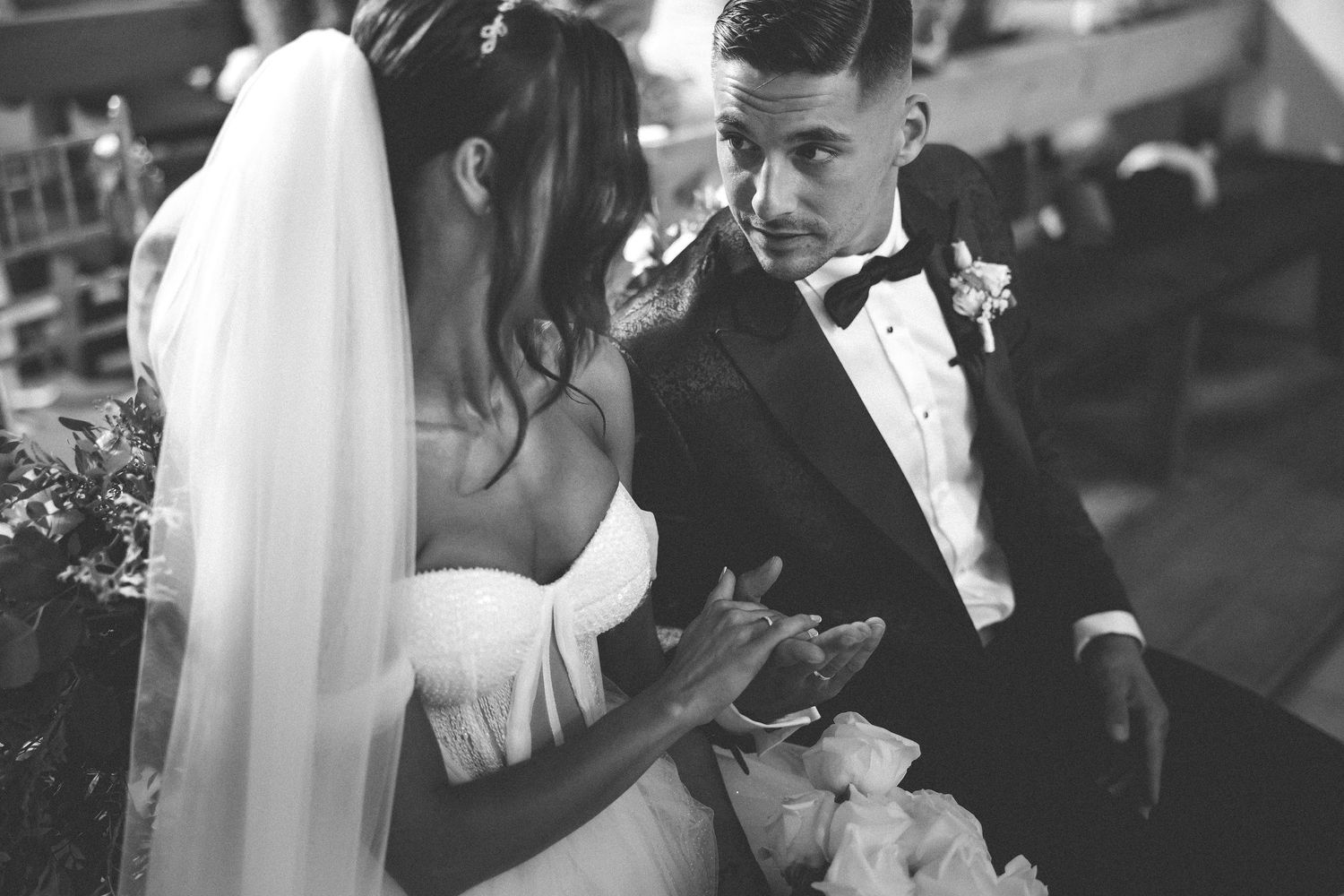 Black and white candid moment of a couple during their wedding ceremony.