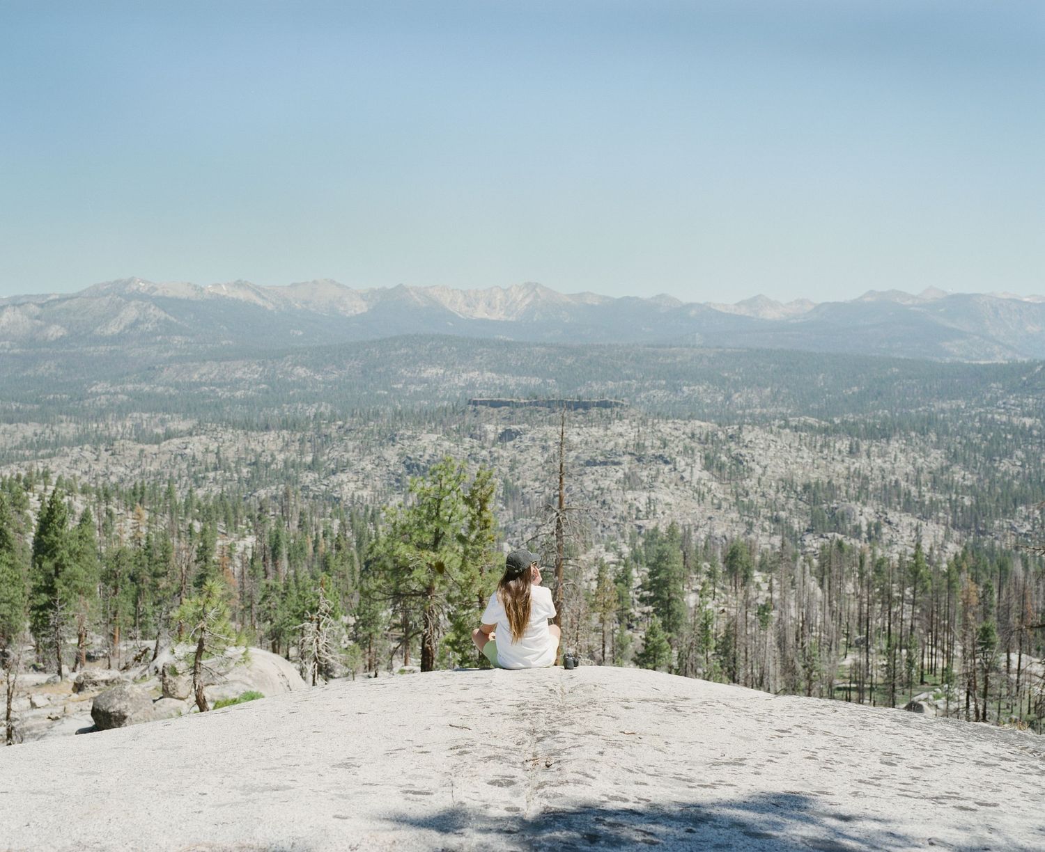 Panoramic winter mountain landscape with snow-covered peaks and evergreen forest.