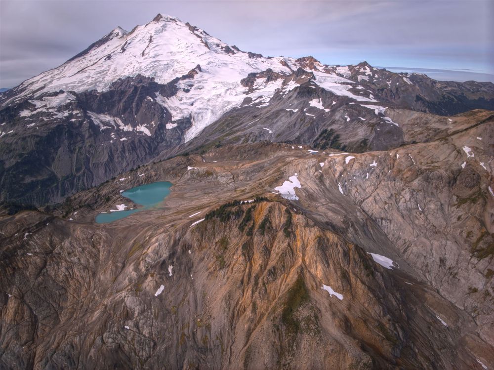 Snow capped mountain with beautiful lake with rocky terrain.
