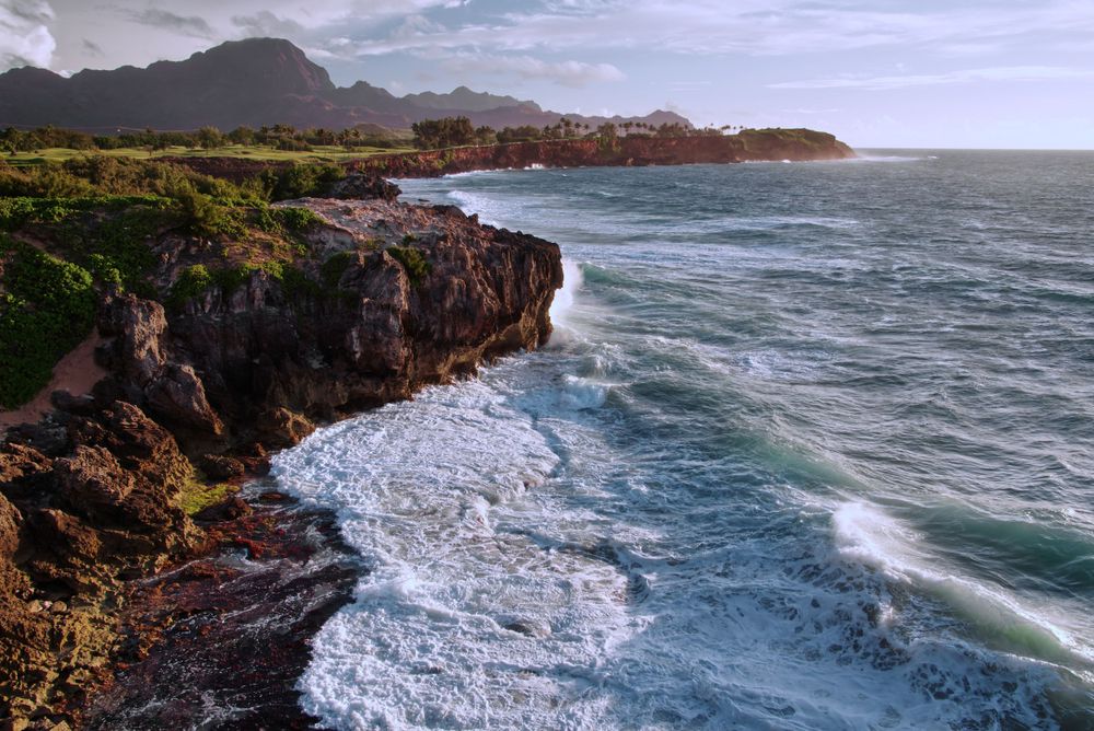 Waves crashing into the cliffs of a beach.