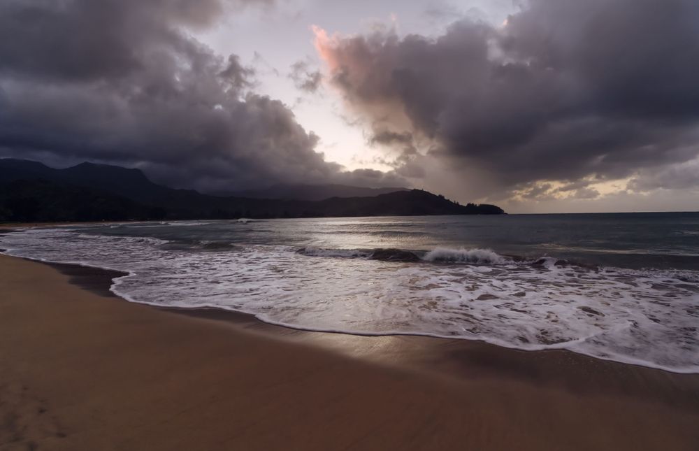 A beautiful beach with dramatic clouds in the sky.