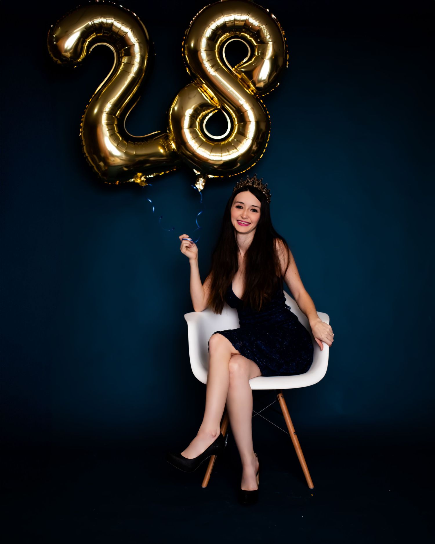 Golden number 28 balloons floating against dark background with elegant celebration setting.