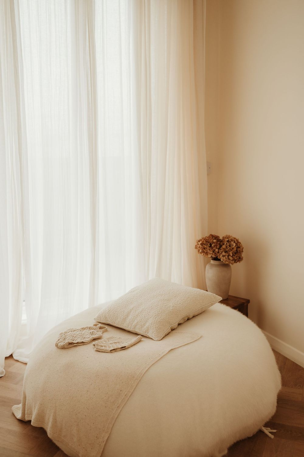 White billowy curtains create a soft, dreamy atmosphere in a minimalist bedroom with natural light filtering through.