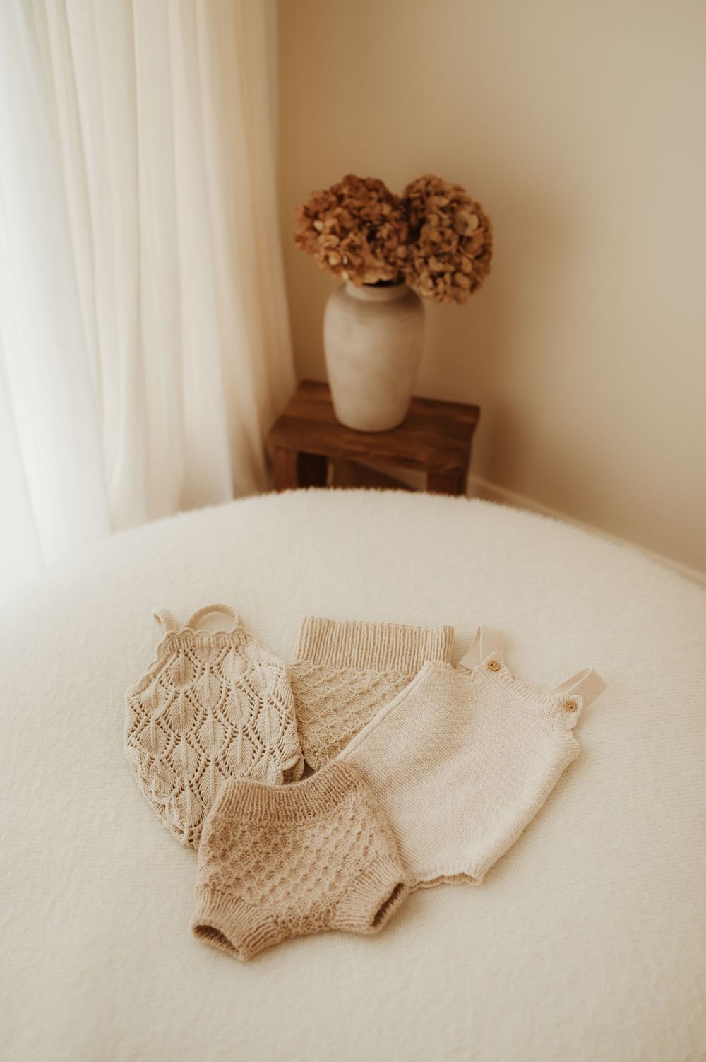 Cozy beige knit textile on white bedding creates a soft minimalist aesthetic with subtle cream tones and natural light.
