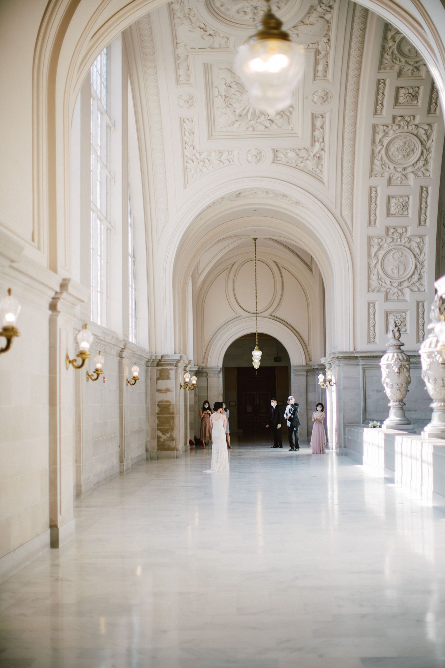 A grand white marble hallway with ornate ceiling details and classic architectural elements.