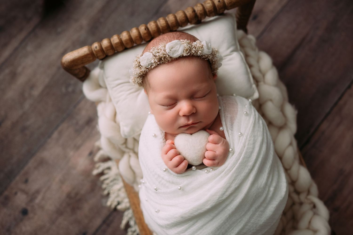 Sleeping newborn surrounded by boutique props in cozy photography studio near the Twin Cities
