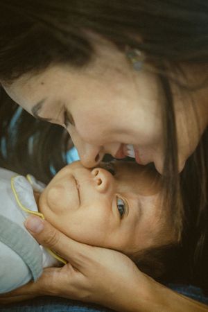 An intimate close-up moment between parent and baby with gentle lighting.