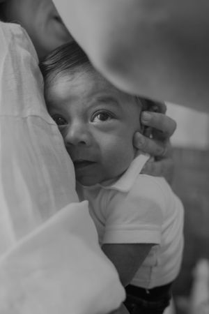 Black and white portrait of a baby being cradled against soft fabric.