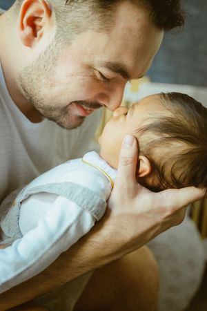 Tender moment between parent and baby as they share a close embrace.