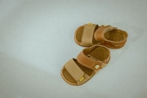 Tan leather baby sandals isolated on white background.