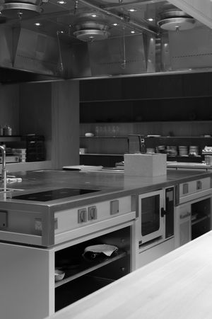 Professional kitchen interior with stainless steel cooking equipment and modern appliances.