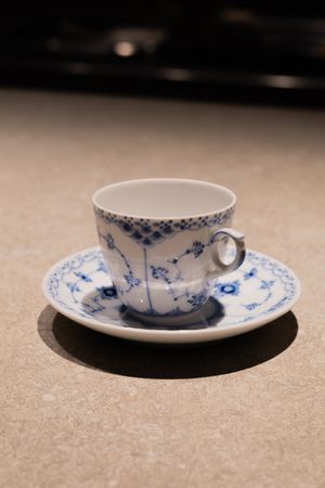 Delicate blue and white porcelain teacup with traditional floral pattern.