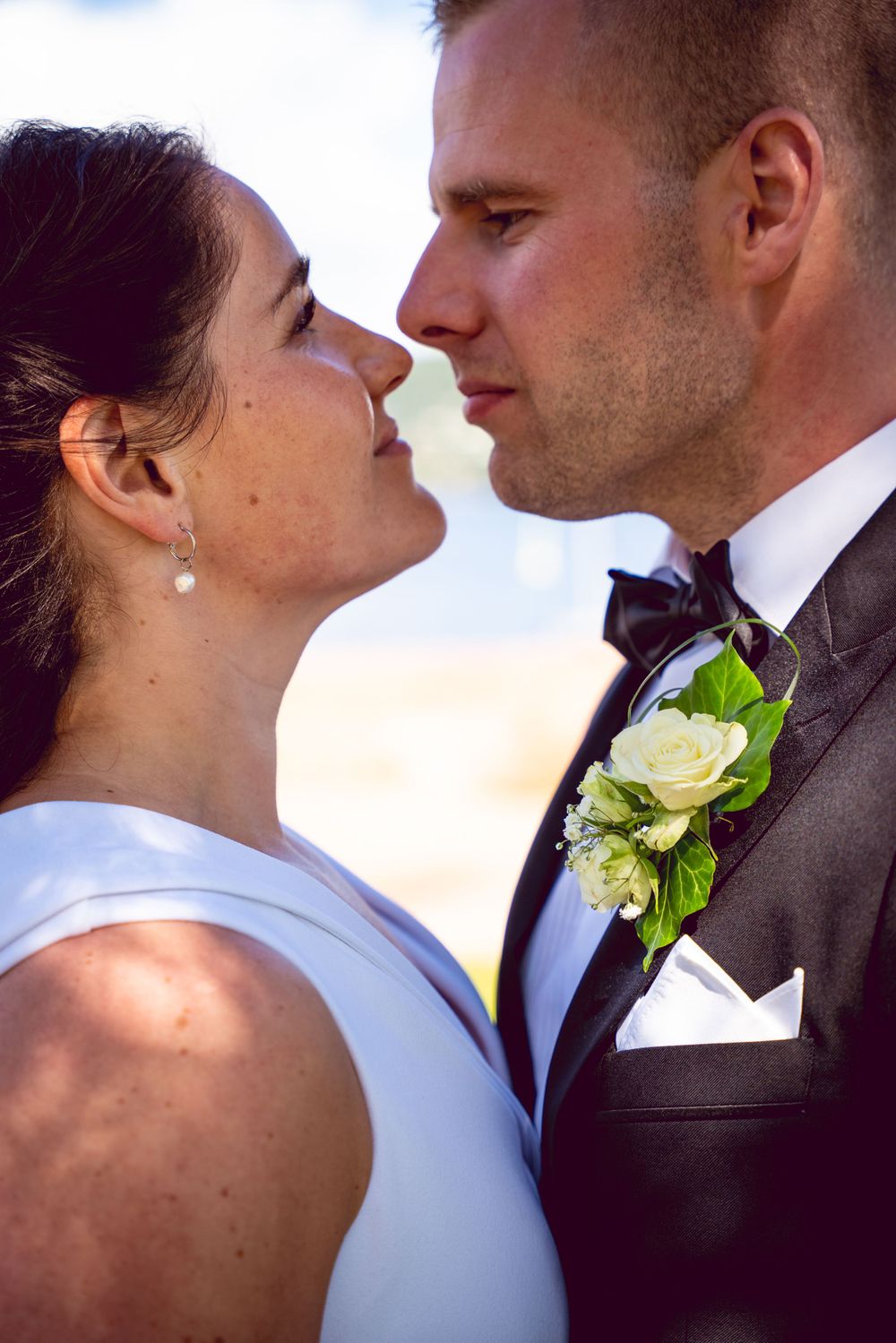 Intimate wedding moment captured with white boutonniere detail.