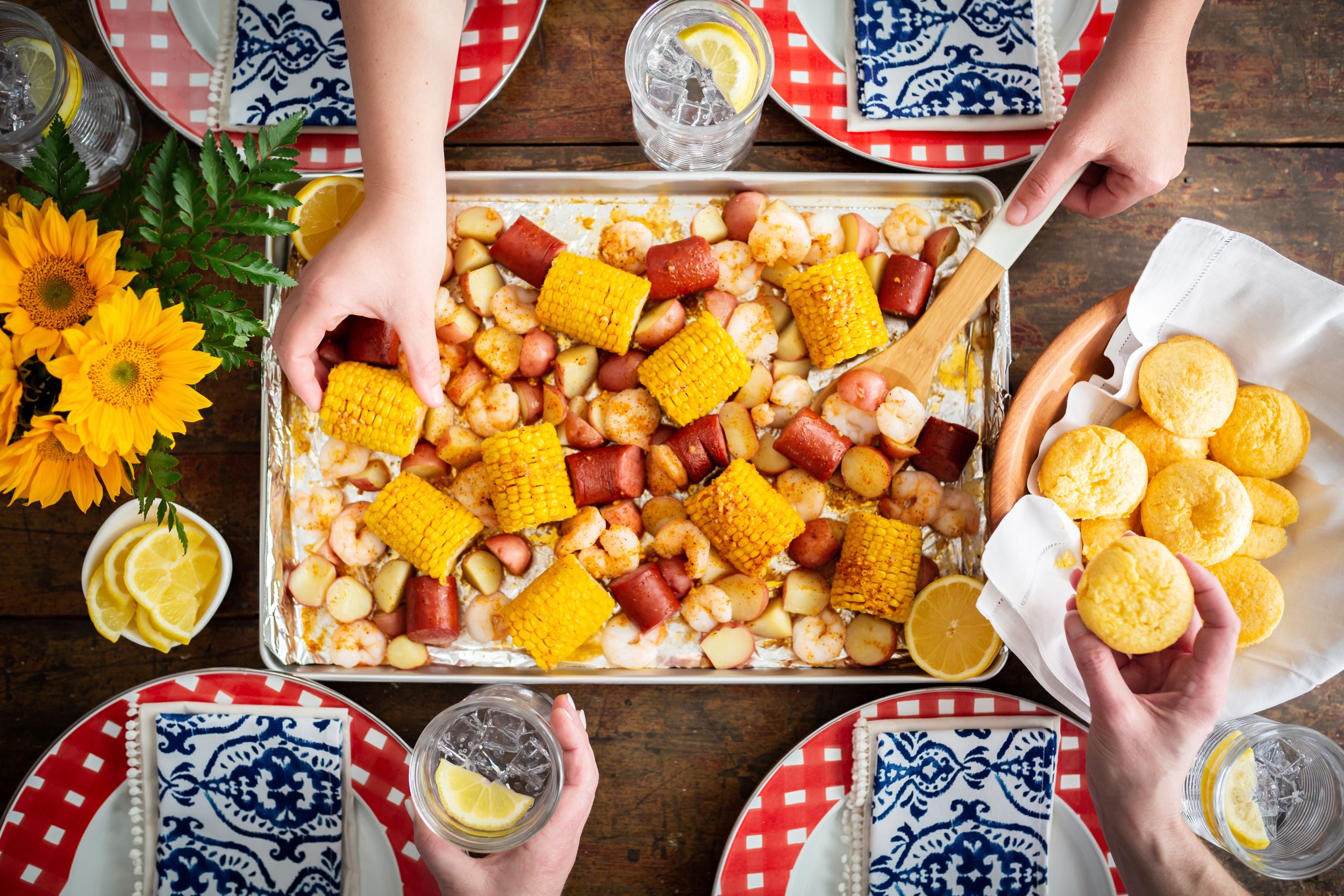 Overhead view of seafood boil with corn and potatoes served on parchment paper with sunflowers.
Commercial Photography
HGTV