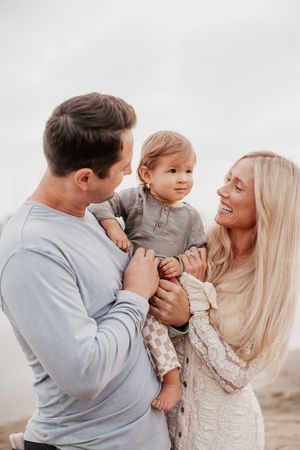 A happy family moment captured on the beach with soft lighting.