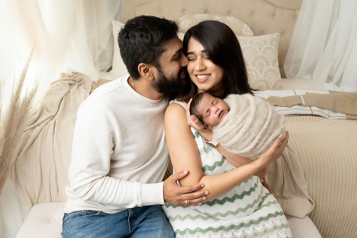 Loving couple embracing on white bed during intimate lifestyle photoshoot.
