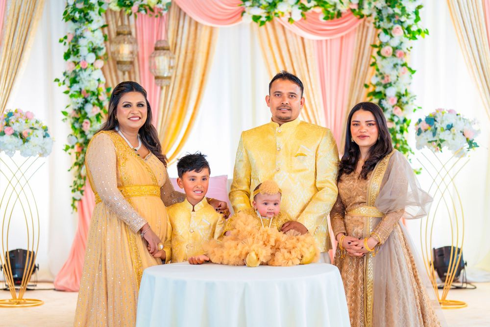 Family group in coordinated yellow and gold outfits poses at decorated event.
