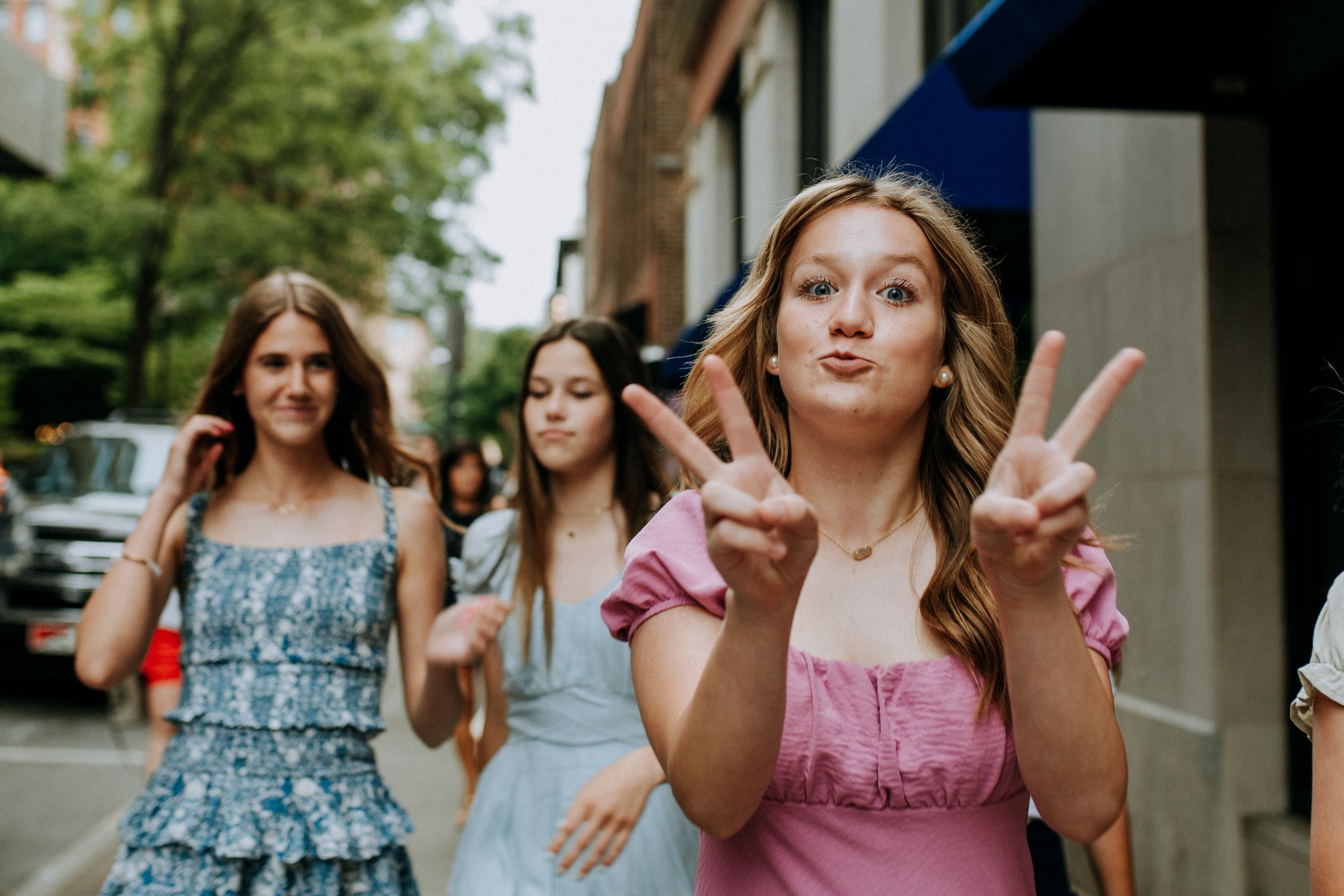 Casual street style portrait with peace sign gesture outdoors.