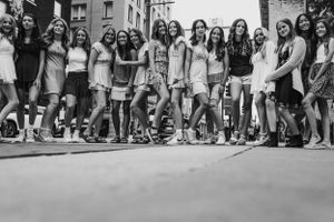 Group of friends posing together on a sunny day in an urban street setting.