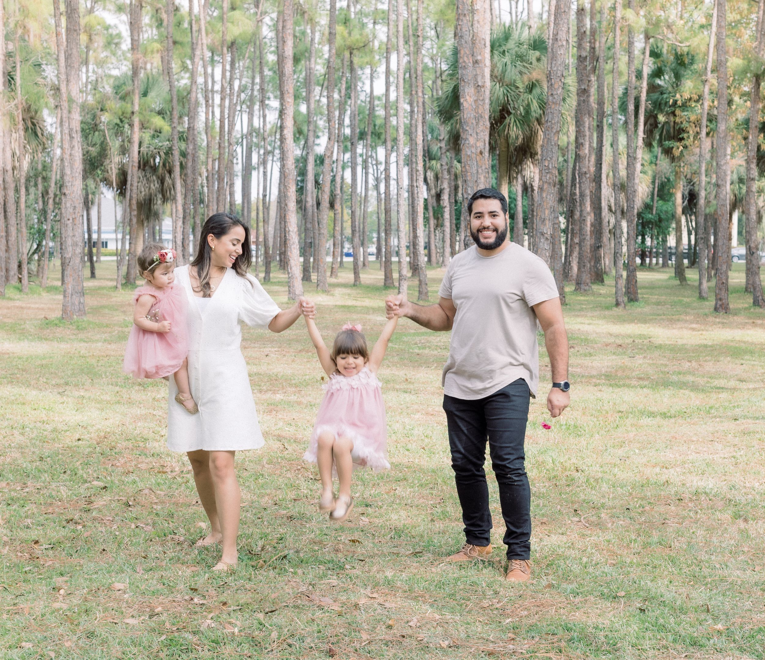 A joyful family walking together through a scenic wooded park.