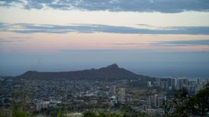 Sunset view of Diamond Head crater and Honolulu skyline from elevated vantage point.