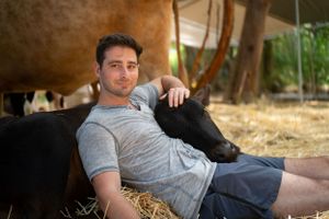 People lounging casually in a rustic barn or farmhouse setting.