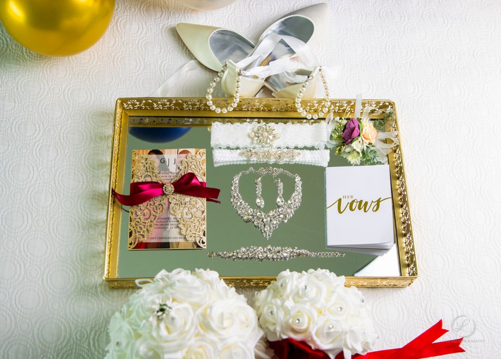 Elegant wedding invitation set with crown motif displayed on gold mirrored tray with white flowers.