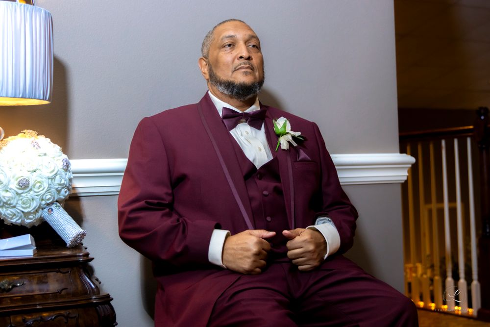 Formal portrait in burgundy tuxedo with boutonniere.