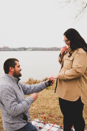 A romantic marriage proposal sequence captured in four photos by a lakeside during autumn.