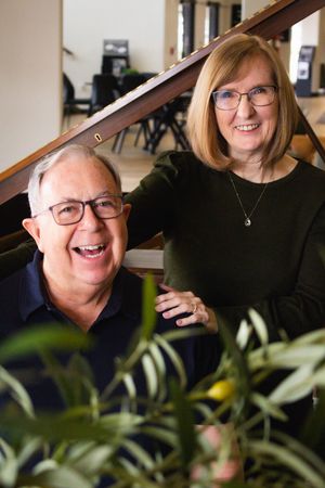 A series of candid portrait photos showing warm smiles and laughter through glass with green plants in foreground.