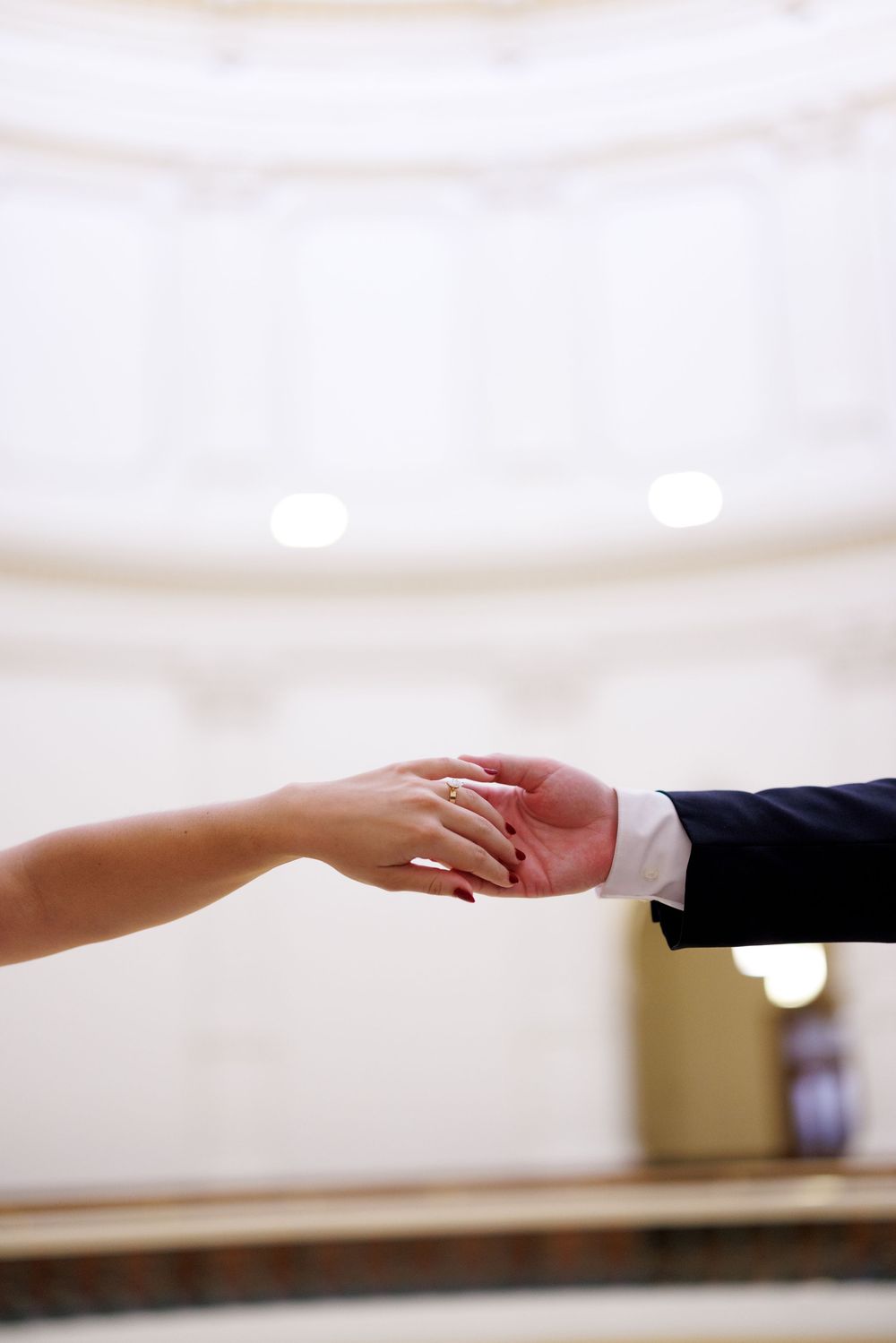 Two hands reach out to touch in an artistic wedding photograph.