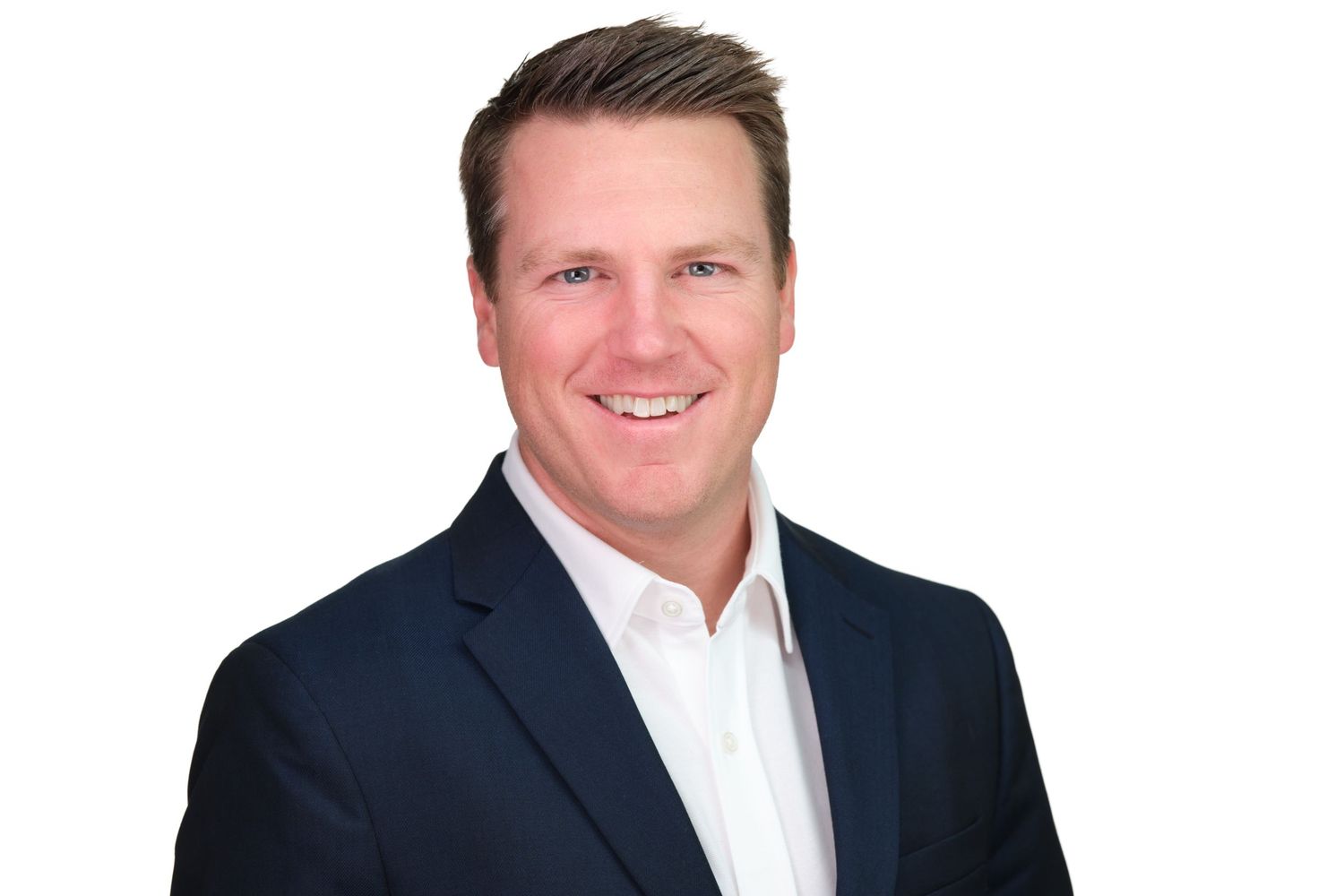 Professional business headshot of someone in a navy suit and white dress shirt against a neutral background. Langley Corporate Headshots.