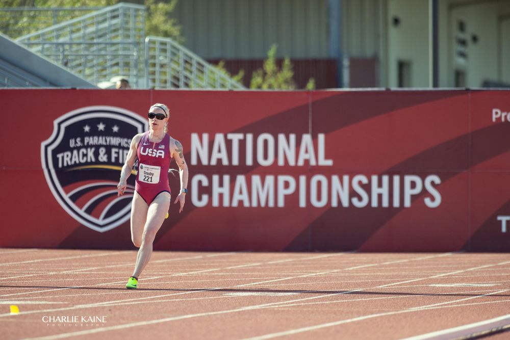 Track athlete performing long jump at national championships.