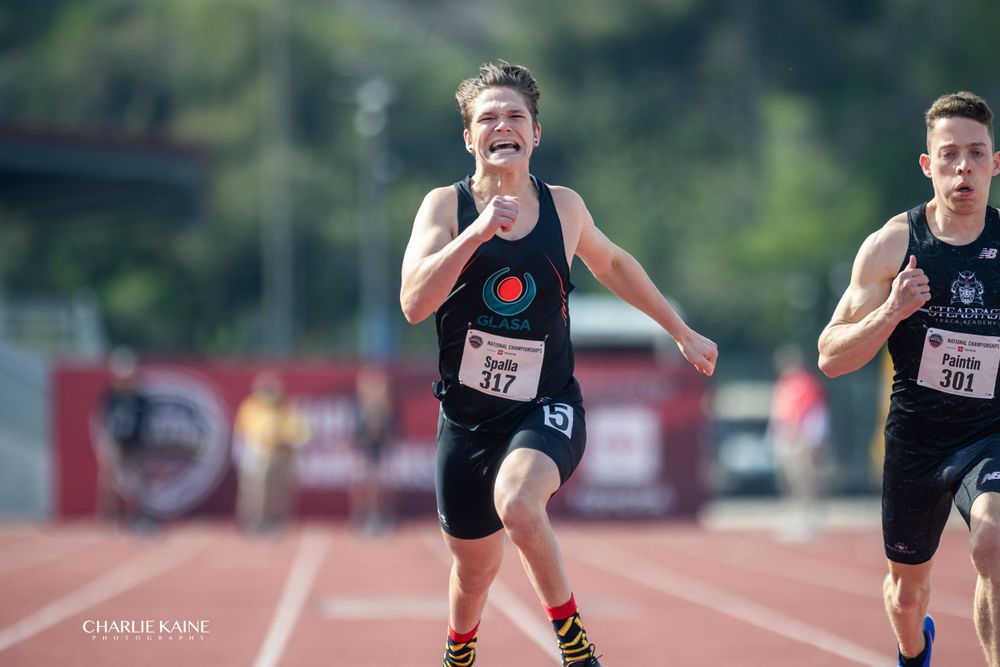 Athletes compete in sprint race on outdoor track.