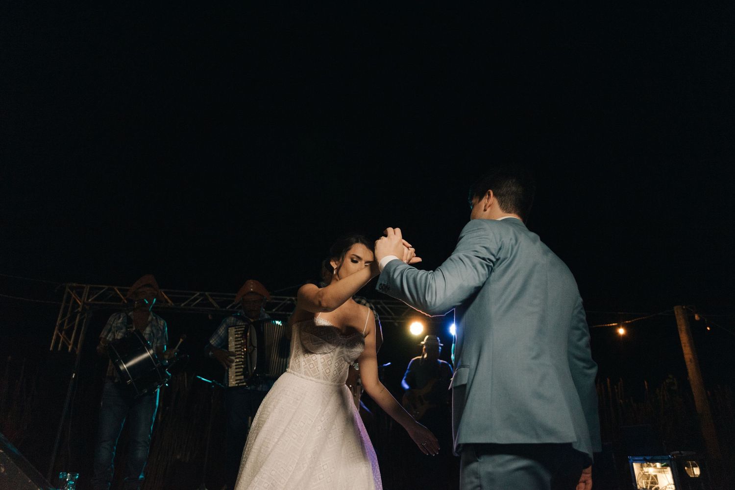 A couple shares their first dance at a nighttime wedding reception.