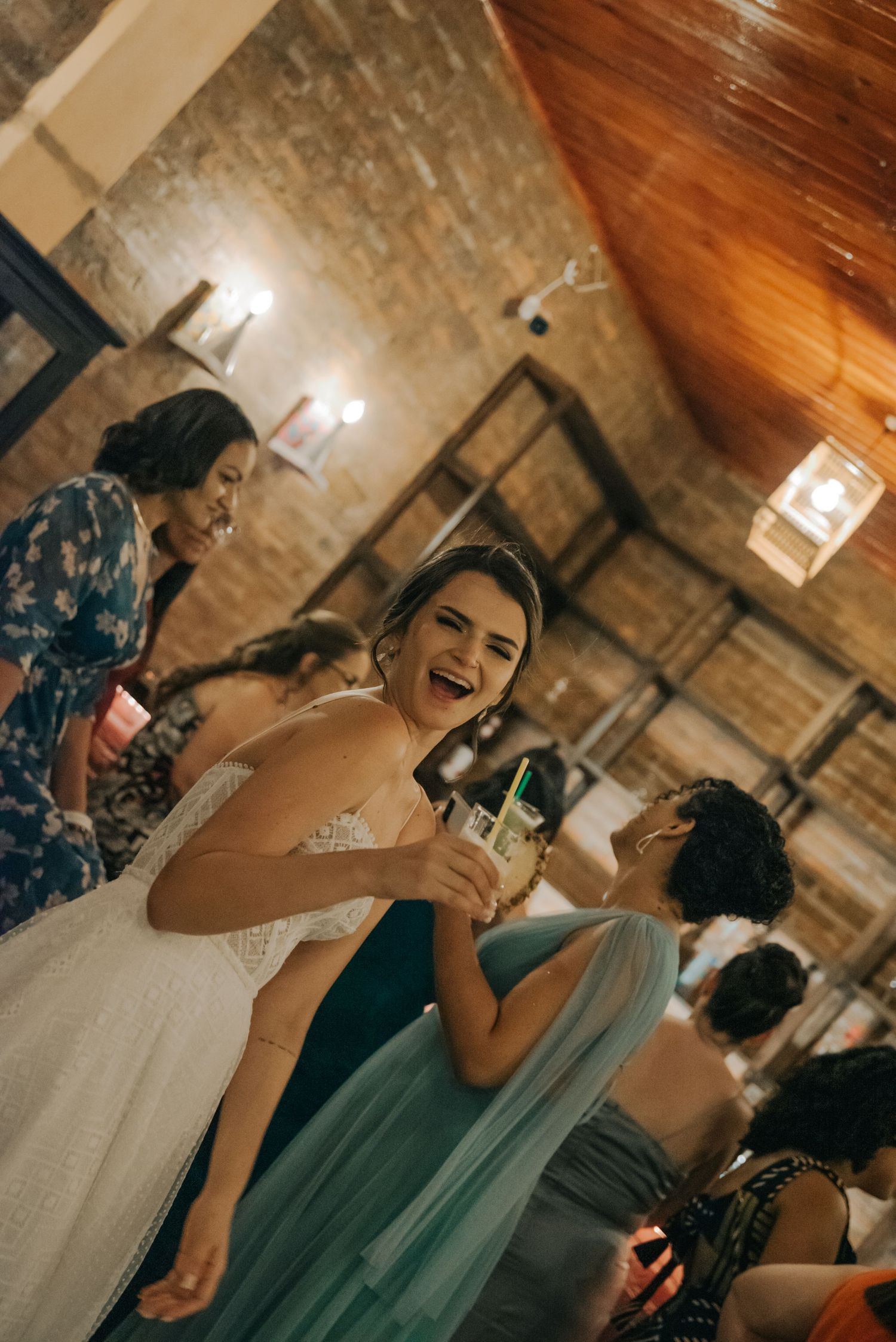 Wedding celebration inside a rustic venue with wooden ceilings and joyful atmosphere.