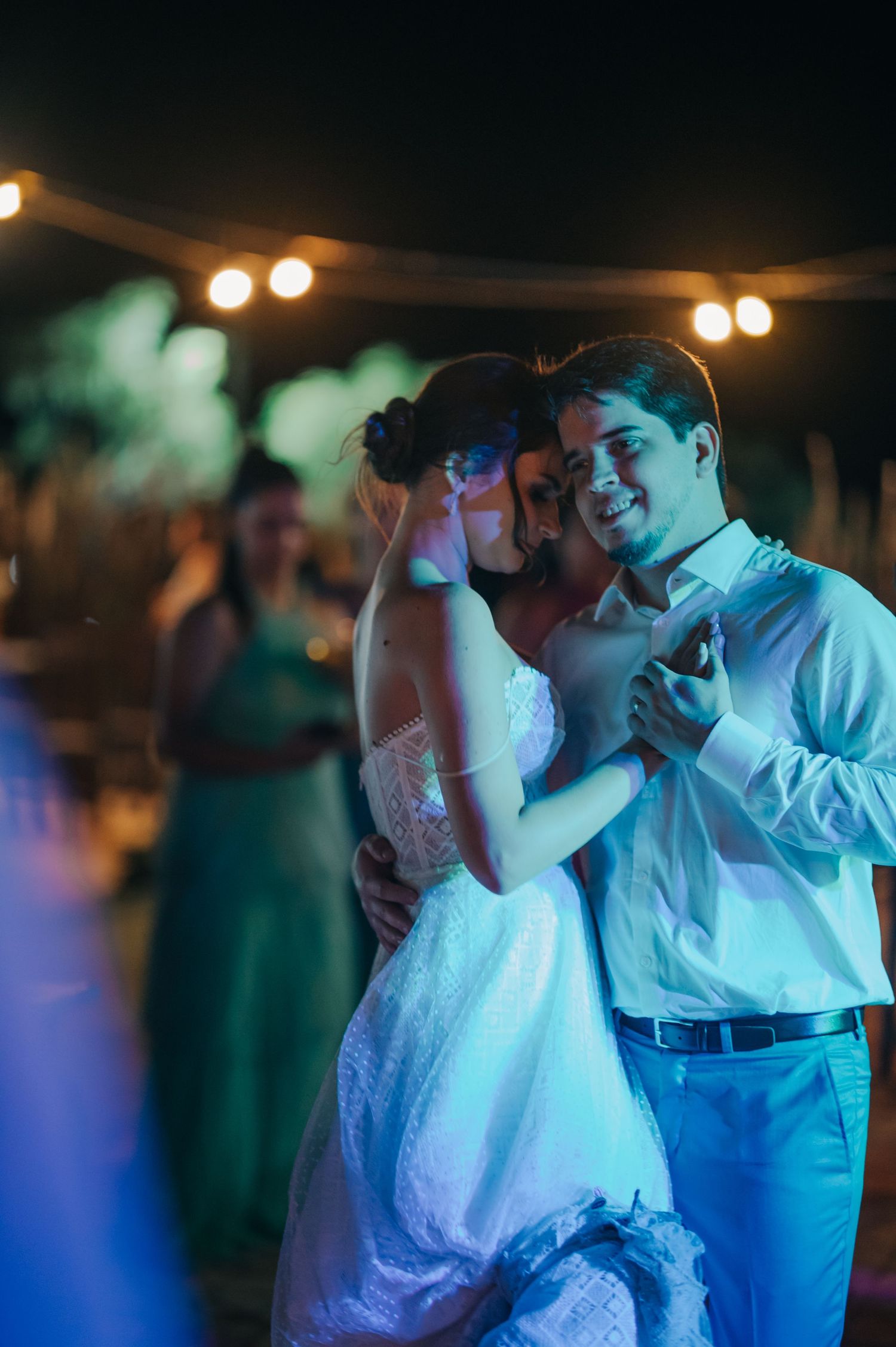 Intimate dance moment under moody lighting at wedding reception.