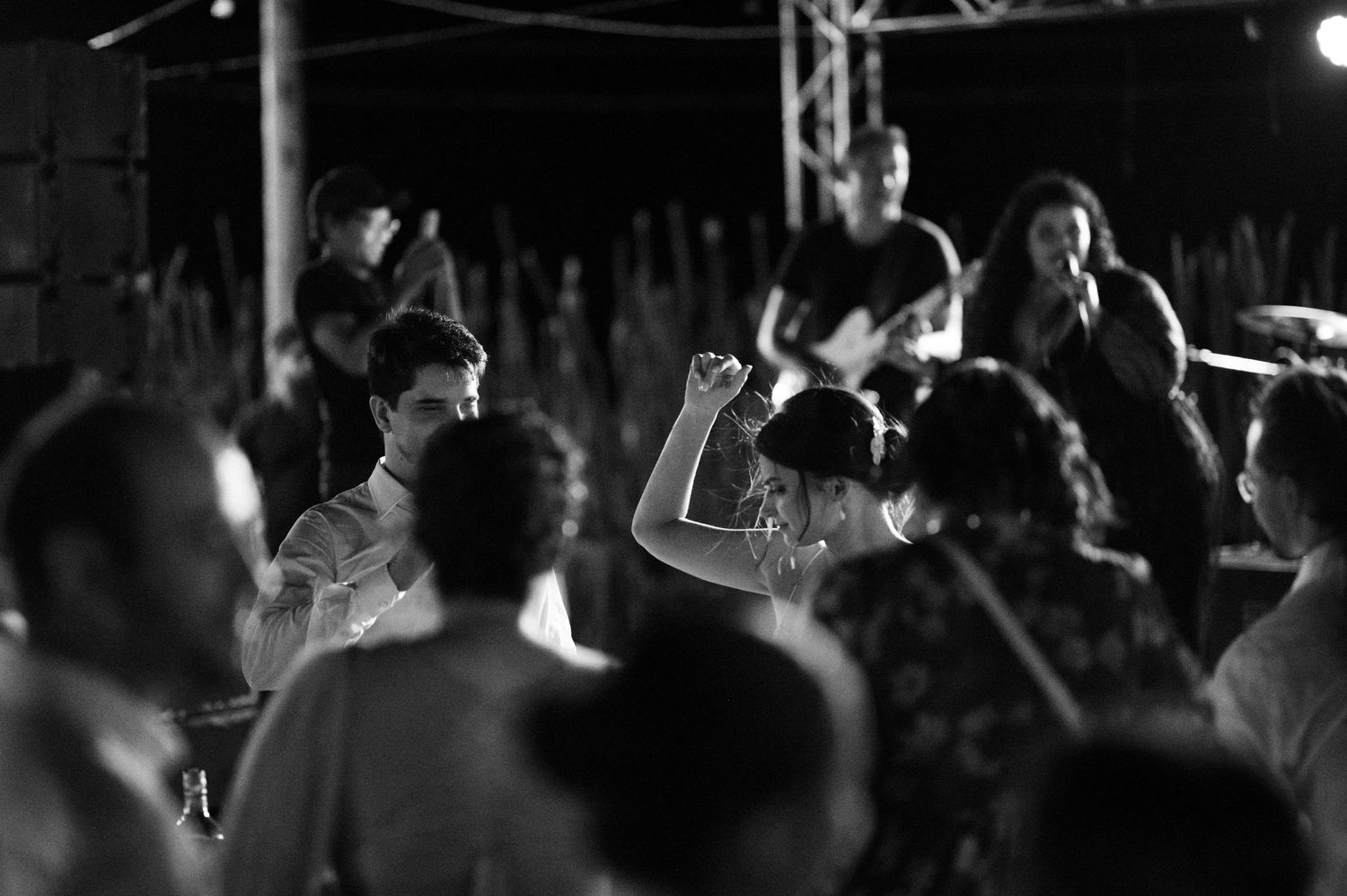 A black and white photo shows people dancing and celebrating at a lively party.