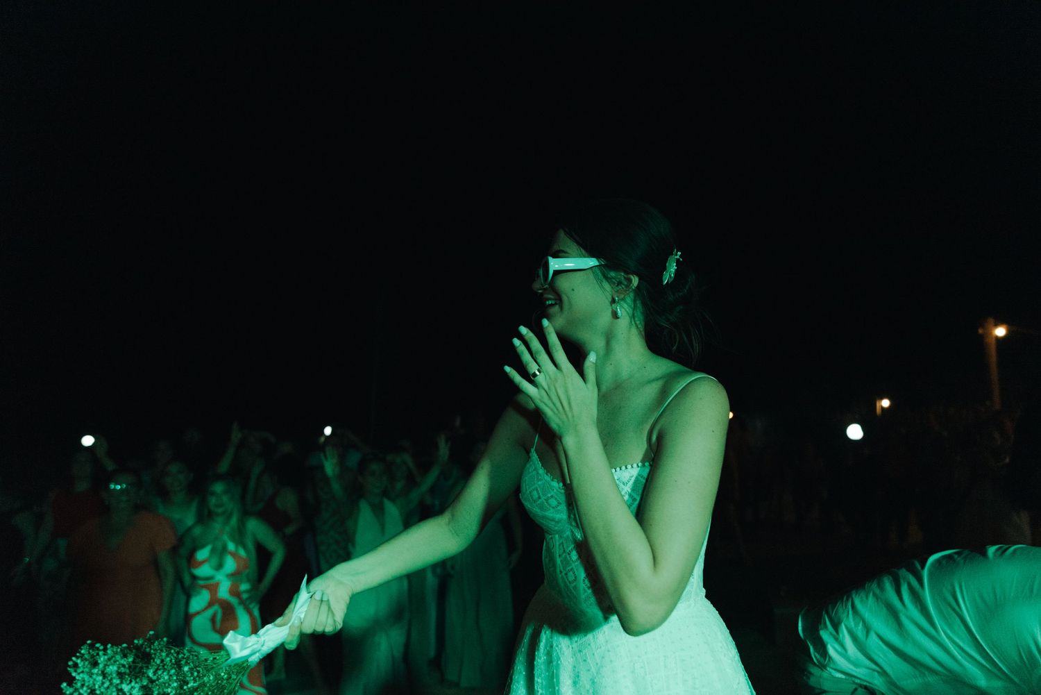 A dancer in white is illuminated by green stage lighting during an expressive performance.