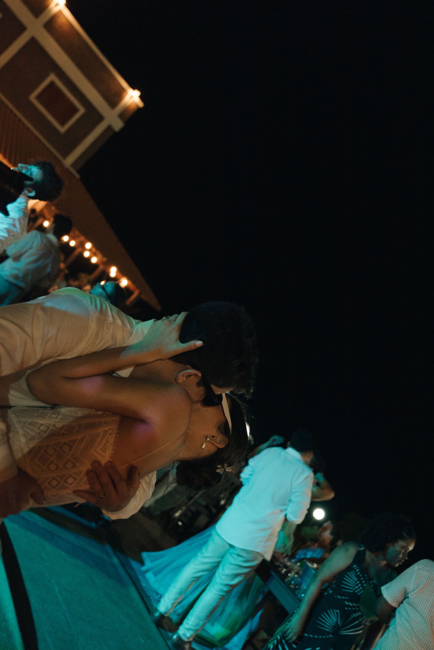 Festive dance party scene with string lights and people dancing.
