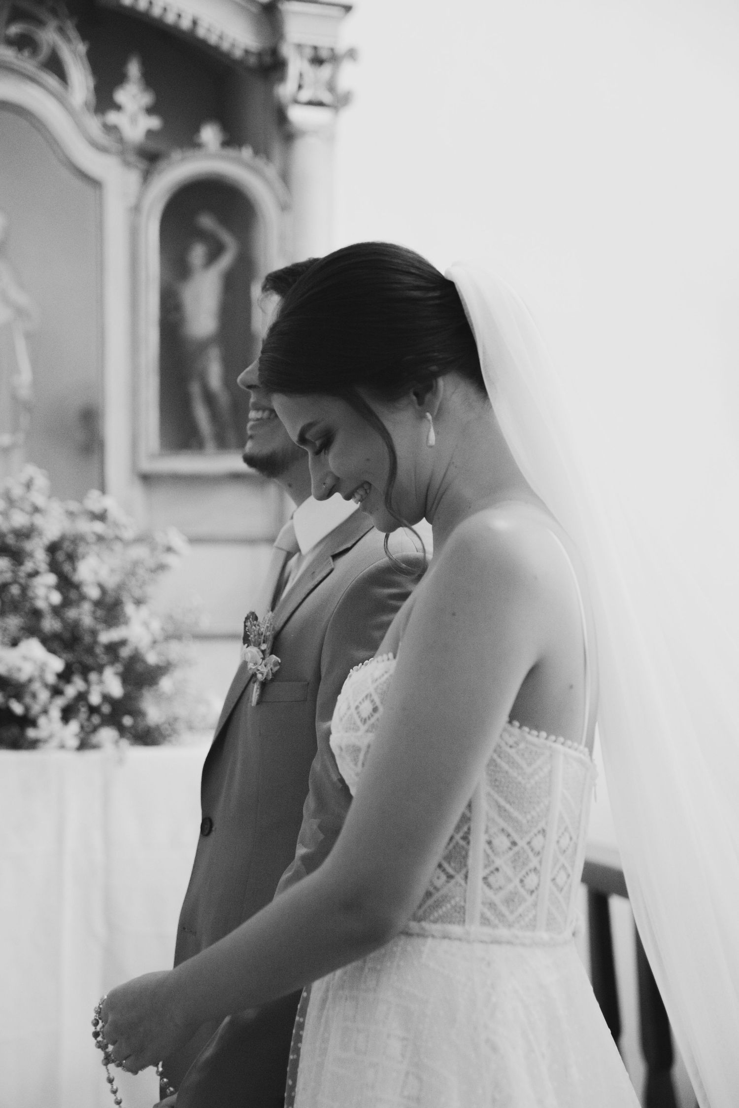A black and white tender moment captured during a wedding ceremony in a church.