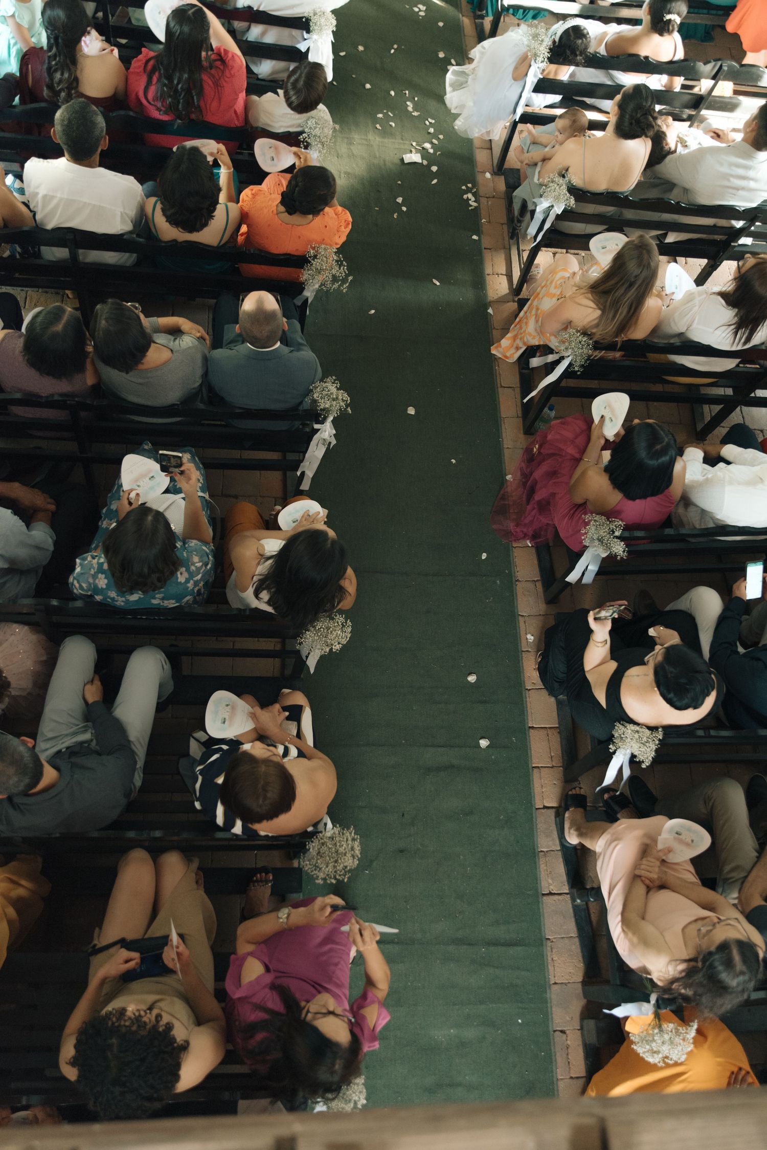 Overhead view of wedding guests seated in church pews.