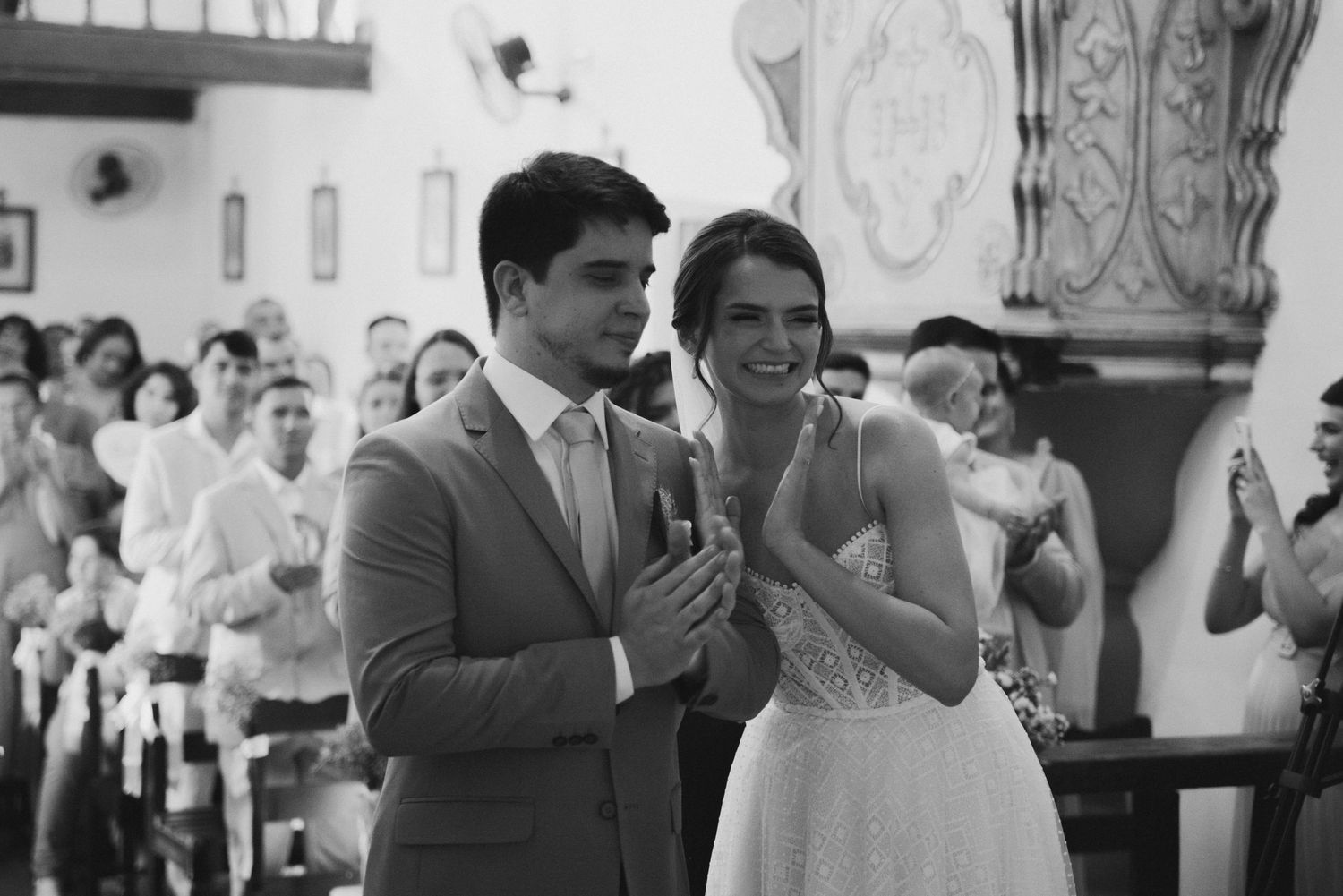 A couple praying together during their wedding ceremony in black and white.